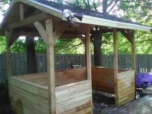 Cedar poolside sitting area with lights near a backyard pool